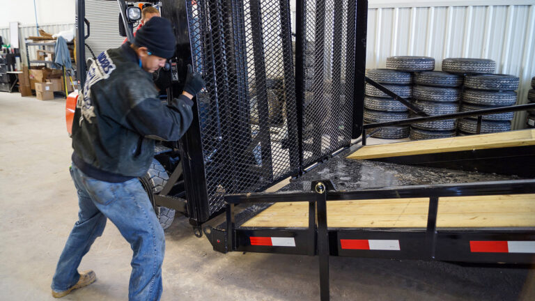 Trailer mechanics install an expanded metal ramp on a trailer at Nationwide Trailer's service department